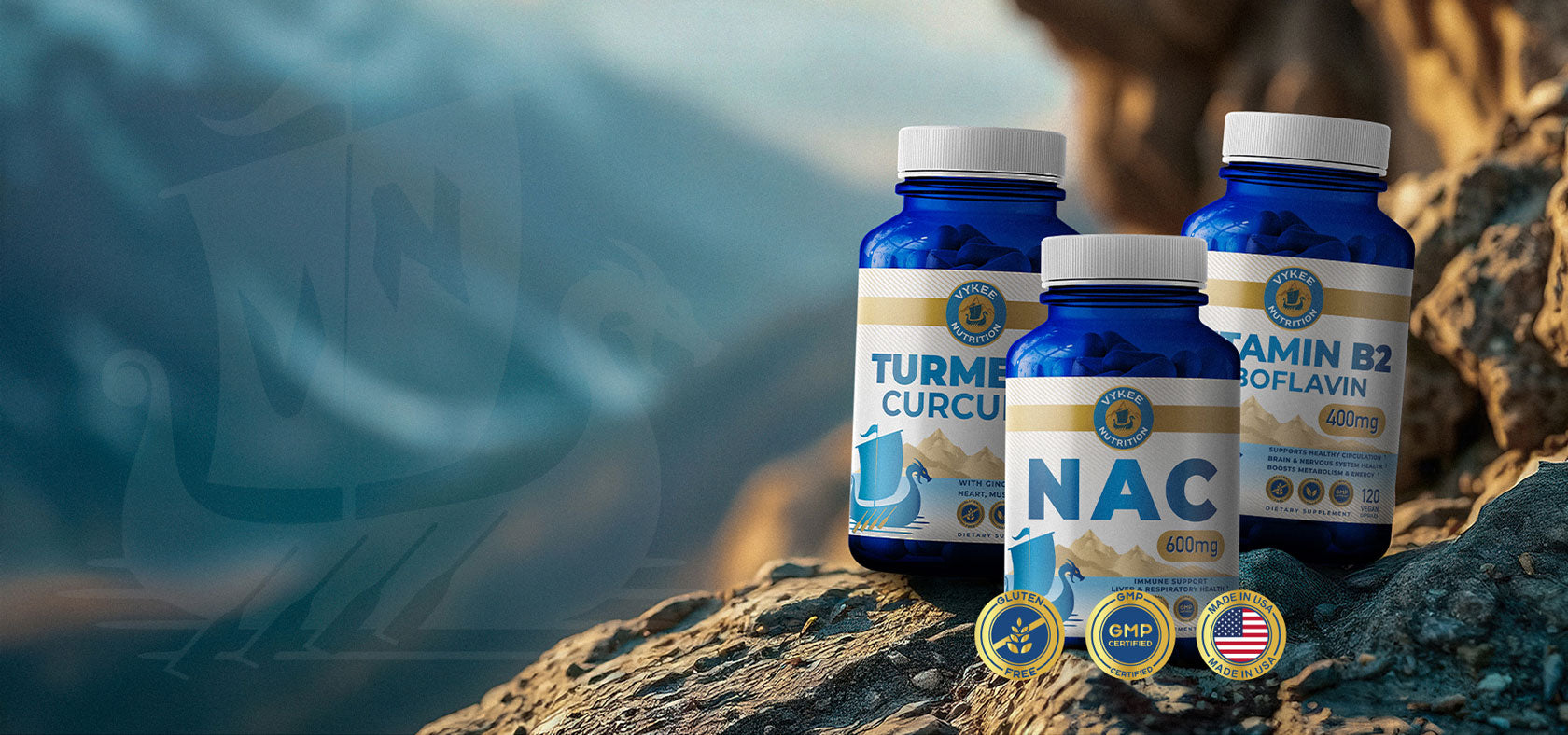 Three Vykee Nutrition supplement bottles standing on mountain rock above a misty fjord
